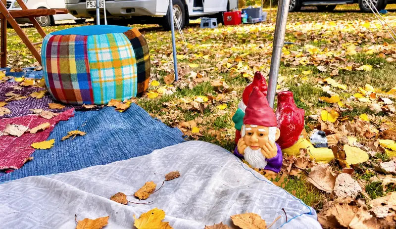 colourful campsite awning setup with footstool and gnome